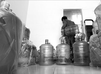 昨天,石景山区一水站的农夫山泉桶装水下架。店内工作人员正在归拢农夫水桶入库。